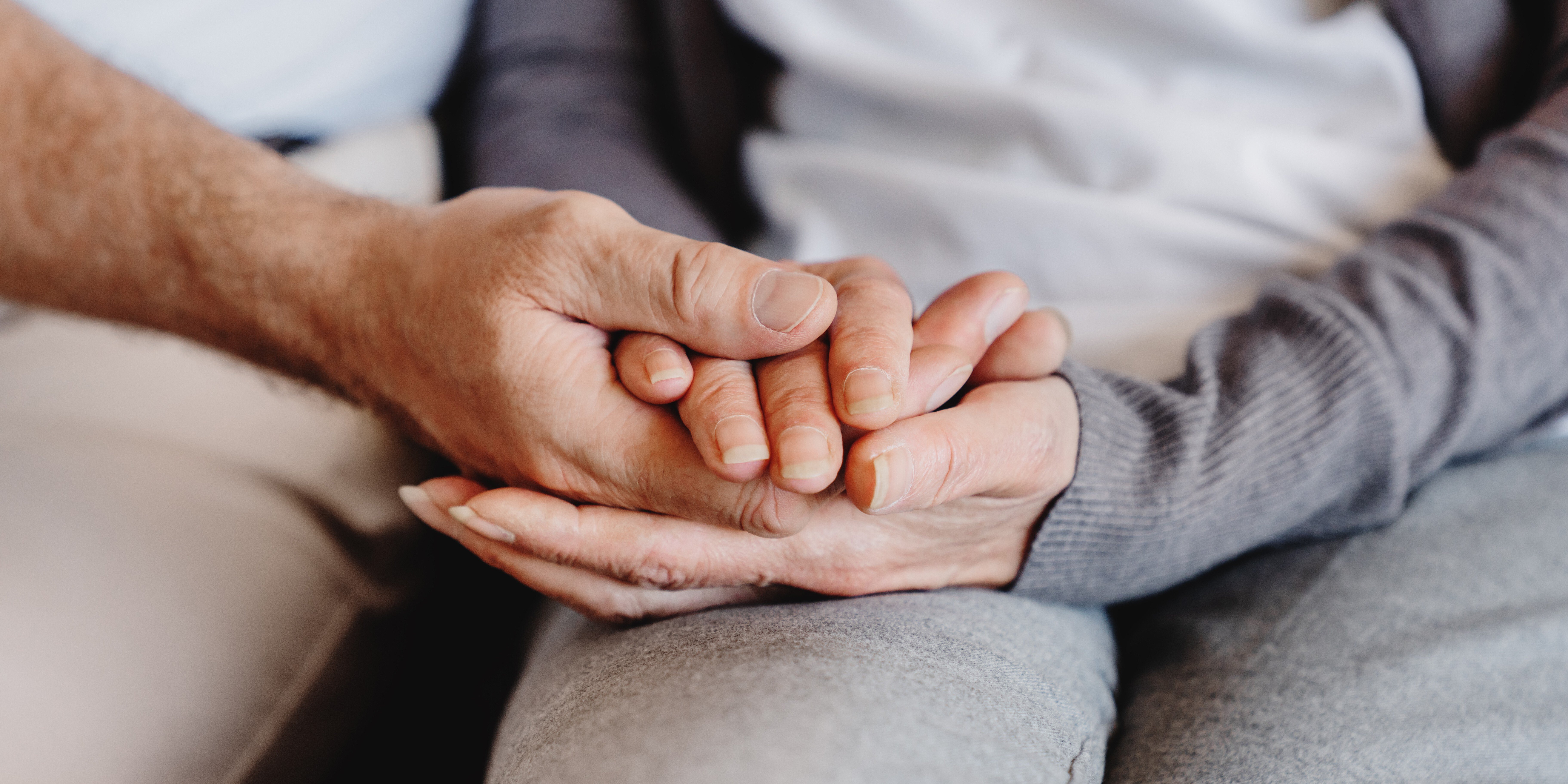 People holding hands while comforting each other.