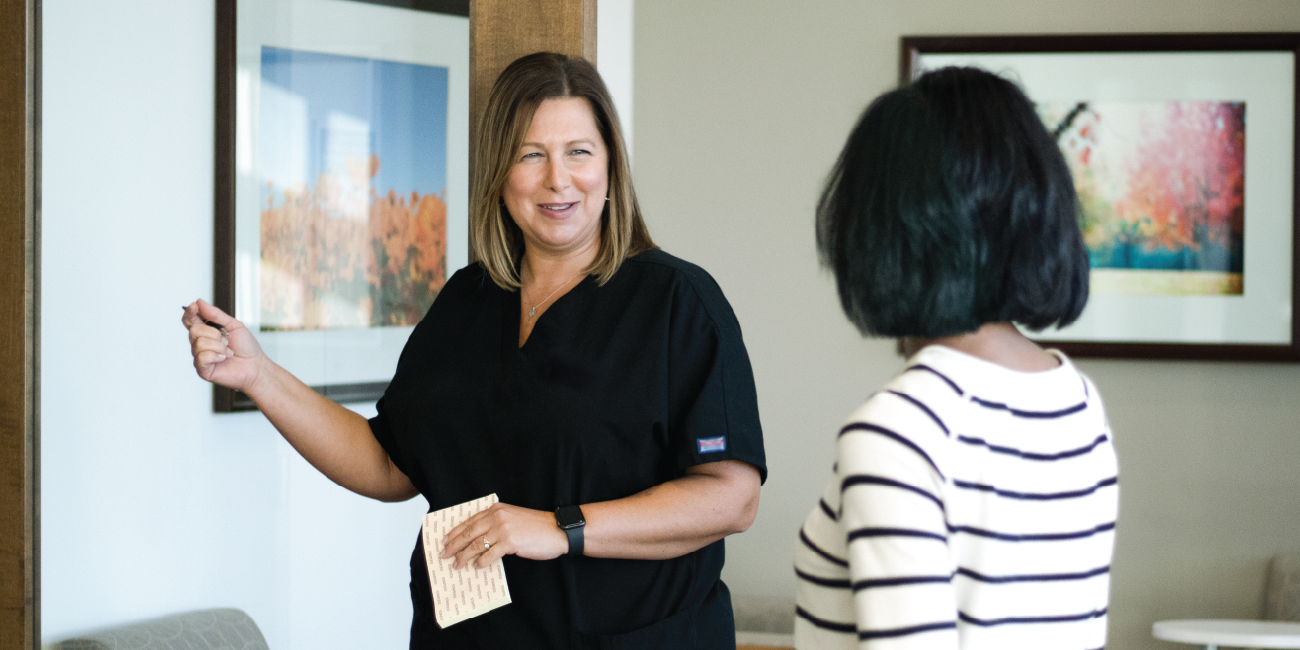 A patient being welcomed into the health center by a member of her care team